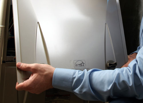 An HVAC Technician changes a furnace filter